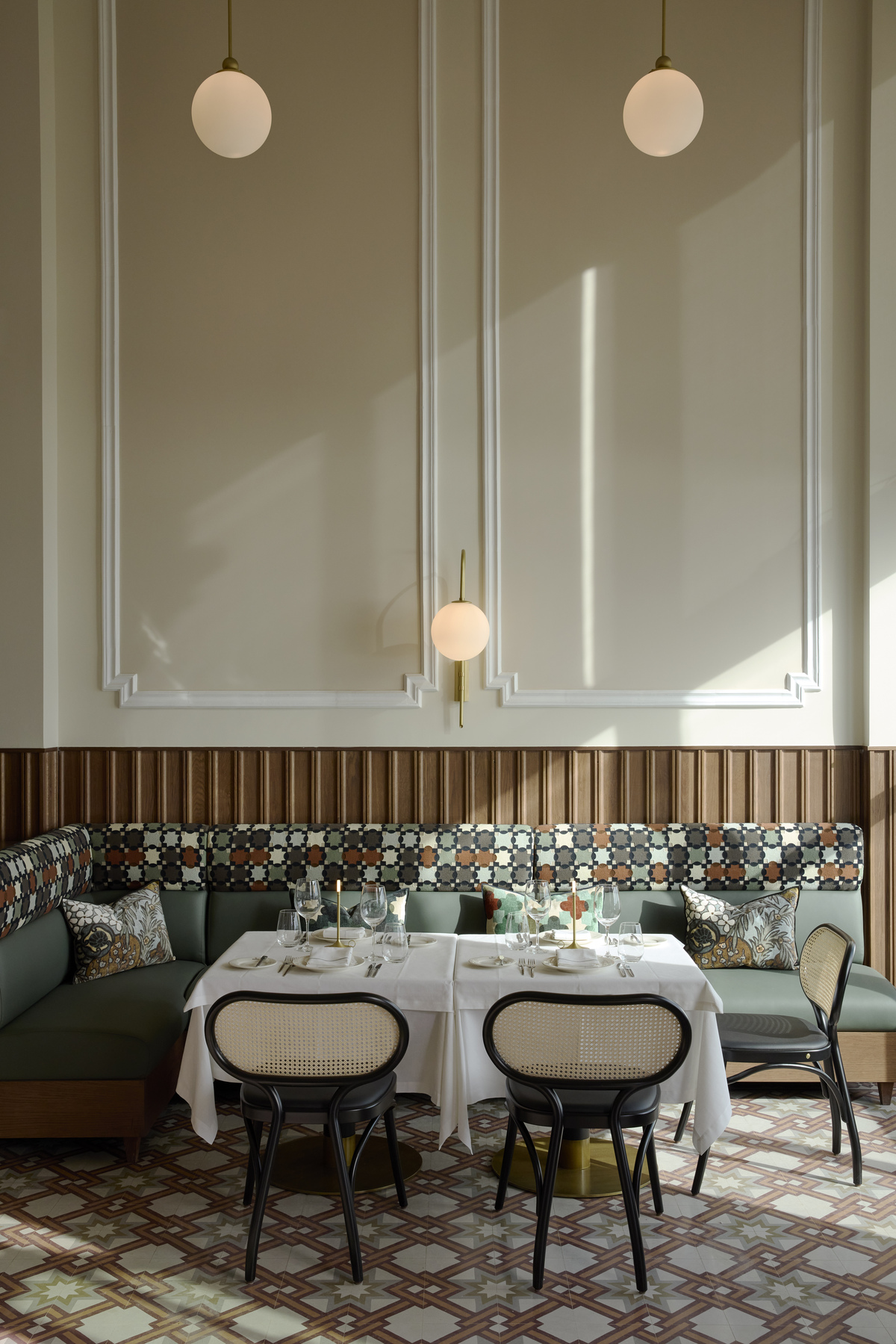 Elegant seating area in Olympos Naoussa restaurant with decorative booth, set table, and modern lighting